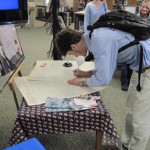 student signing at table